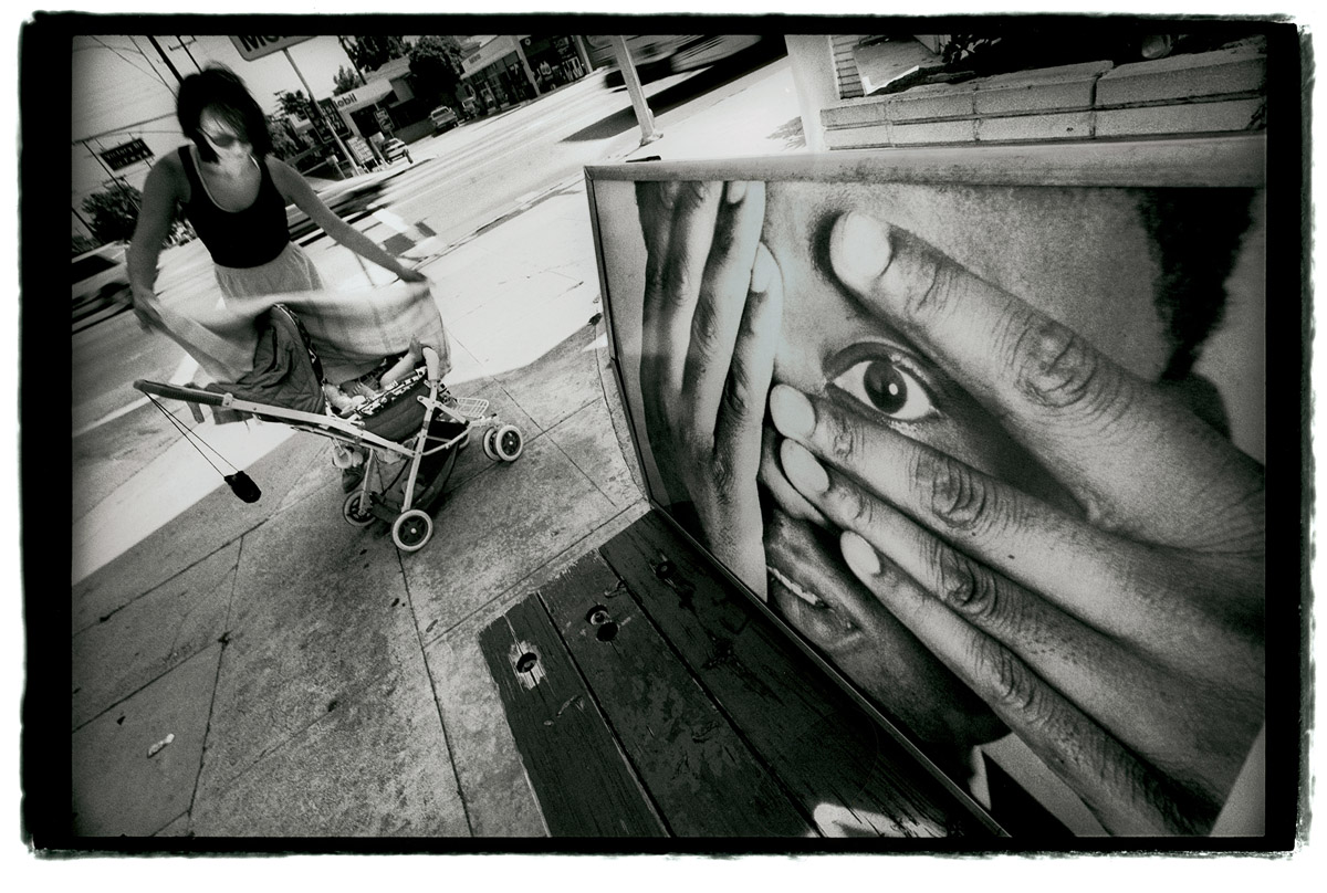 This image of a man looking through spread fingers was posted throughout Los Angeles for a short period of time during the middle of 1995